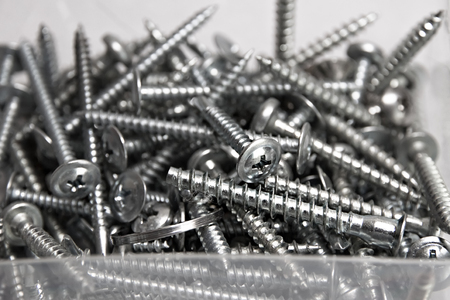 Many screws nails lie in a transparent boxの写真素材