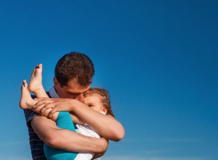 man holds in his arms hugs his childの写真素材