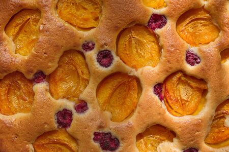 dough pie with fresh apricots and raspberries close-upの写真素材