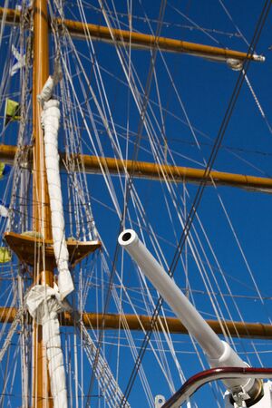 white gun on background masts of parsing ship mast sailing ship against the blue skyの写真素材