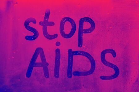 blue neon words stop AIDS with written finger on foggy glass on drops window concept photo with copy...