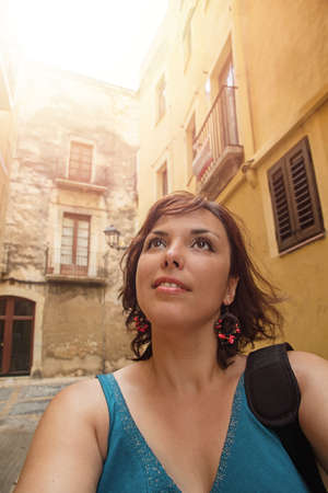 30 years old girl with brown eyes and dark short hair in turquoise T-shirt with black bag on his...