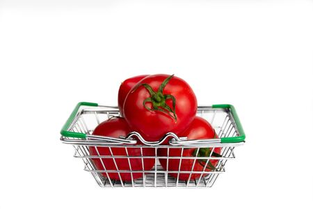 vegetables red three fresh love apples lie in the store's metal grocery basket on white backgroundの写真素材