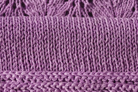 knitted complicated dress made of cotton purple color with openwork on lilac background, copy space