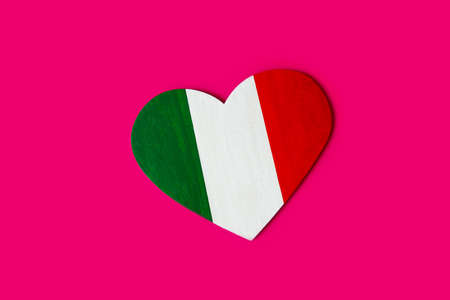 wooden heart painted in colors of flag of Italy green, white and red on magenta backgroundの写真素材