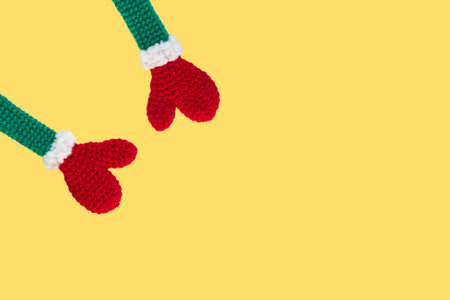 two knitted new year, christmas toys red mittens on green sleeves with white cuffs top left...
