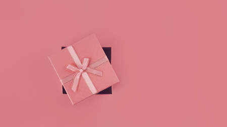 pink holiday box with bow on pink background, banner, 16: 9 copy space, top viewの写真素材