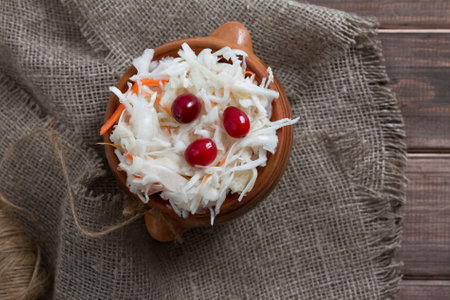sauerkraut with cranberries on wooden table on sackclothの写真素材