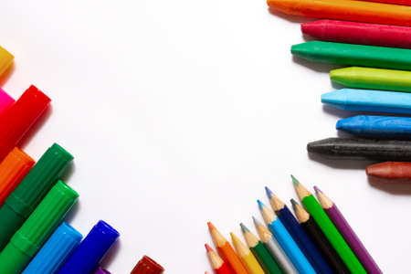 Art supplies for painting: Felt-tip pens, colored pencils and multicolored wax crayons on white paper. Copy spaceの写真素材