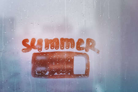 Hand drawn orange shape battery and word summer on muddy glass wet orange window in city on sunsetの写真素材