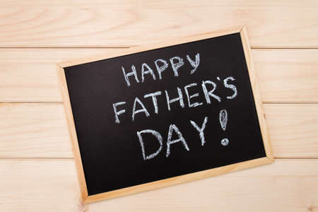 Happy fathers day on chalk board on wooden light backroundの写真素材