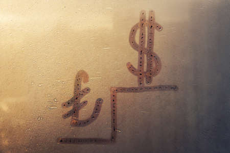 Handwritten sign doodling turkish lira, american icon and sad ladder on suset foggy glass window, concept of fall in Turkish currencyの写真素材