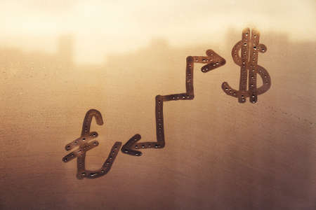 Handwritten doodling sign turkish lira, american dollar icon and ladder with arrows on sunset foggy glass windowの写真素材