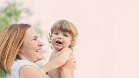 portrait of a happy mother and a small child son in the summer on the street