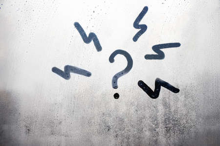 doodle question mark with lightning in circle n foggy glass on city window, concept photo