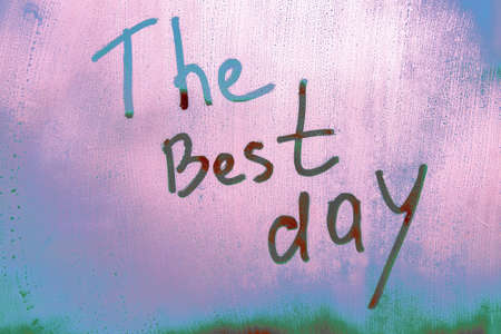 The Best day message written finger on foggy glass wet purplish blue windowの写真素材