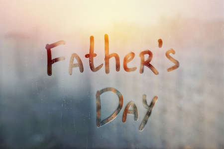 Handwritten lettering message Fathers day on misted orange sunset window with raindropsの写真素材