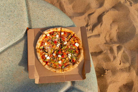Italian pizza lies on table at beach sea, copy space