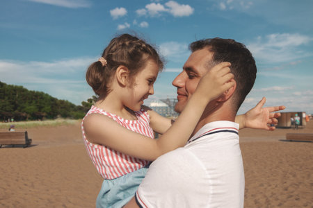 little happy daughter hugs daddy on sunny dayの写真素材