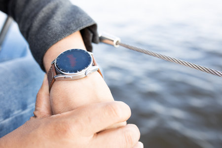 smartwatch on mans hand against the background of seaの写真素材