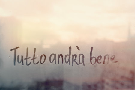 Lettering Italian text Tutto andra bene everything will be fine in english on sunset wet windowの写真素材