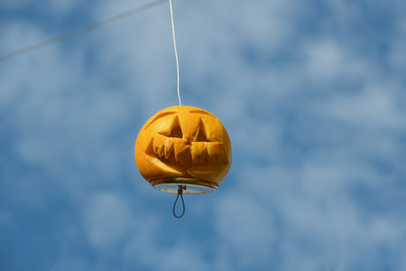 natural orange lantern monster made from pumpkin for halloween holiday on blue sky backgroundの写真素材