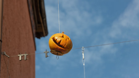 natural orange lantern monster made from pumpkin for halloween holiday on blue sky background neaar houseの写真素材