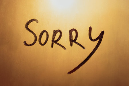 Handwritten words Sorry on foggy glass of sunset windowの写真素材