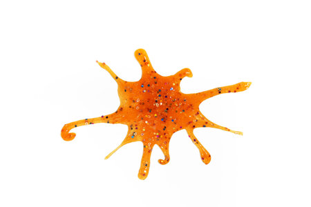 blot from orange slime with sequins on white backgroundの写真素材
