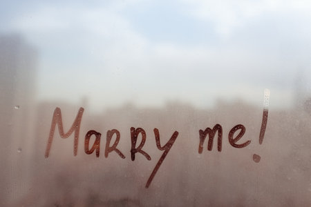 Handwritten lettering marry me on windowの写真素材