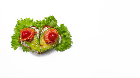 sandwich of heart shaped grain bread curd cheese, avocado salmon, lettuce, cherry tomatoes sesame on white backgroundの写真素材