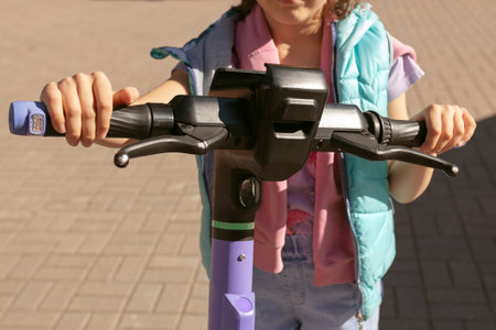 childs hands on the steering wheel of an electric scooter, rental serviceの写真素材