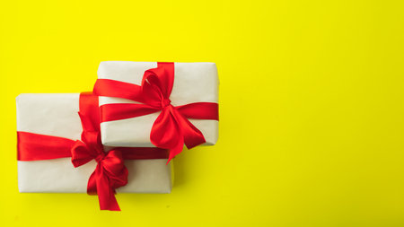 banner two gifts in brown craft paper and red ribbon with bow on yellow background