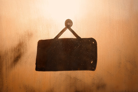 Hand drawn doodle shape signboard for text on muddy orange sunset glass wet window in cityの写真素材