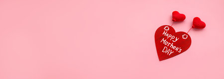 banner wooden red heart with white inscription happy mothers day and knitted hearts on pink backgroundの写真素材