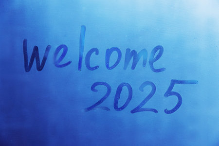 lettering Welcome and numbers 2025 of new year paint with finger on splashed by rain foggy glass on...