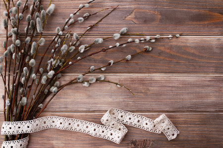 willow branches and cotton ribbon on brown old wooden backgroundの写真素材