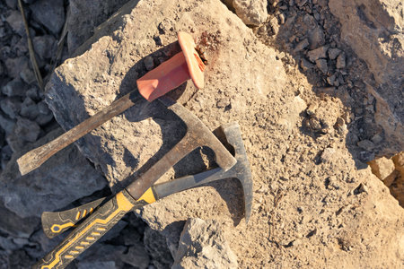 Two hammers and chisel lie on limestone stoneの写真素材