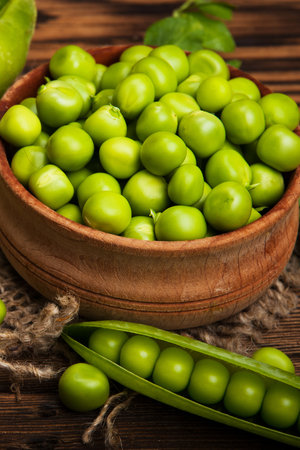 Fresh organic green peas on a wooden background. Rustic style.の写真素材