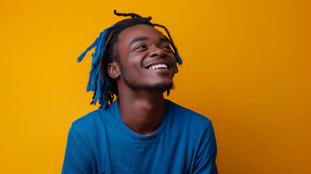 Side view portrait of young African man with dreads in shirt looking straight against yellow studio background. Concept of youth, human emotions, lifestyle, fashion, facial expressions, adの素材