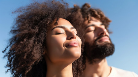 Couple with passive faces stand close, eyes closed. Love and romantic concept. Couple in love with sunset on background, defocused. Man with beard holds womans head with tenderness, close up.の素材