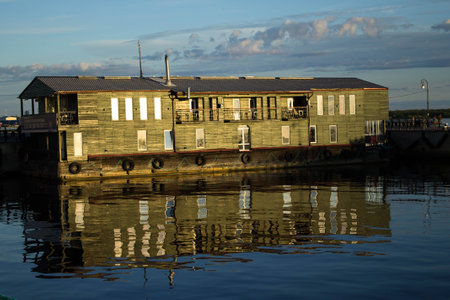 Floating house reflected in the river water on a sunny dayの写真素材