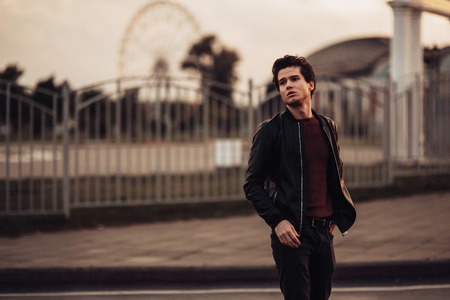 sexy man in modern classic clothes. sunset. park background