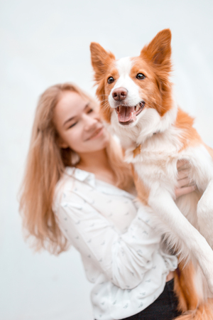 portrair of happy girl cuddle red and white cute dog border collieの写真素材