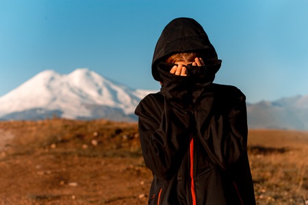 amaizing sexy young girl in hood in field in mountain smilingの写真素材