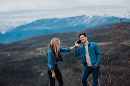 Couple family traveling together on cliff edge. man and woman lifestyle. concept summer vacations outdoor view mountain top. on blue mountains backgroundの写真素材
