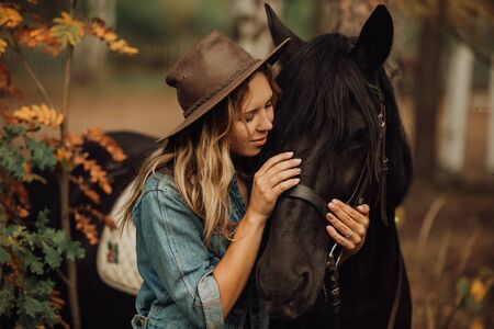 hipster girl with a horse in the woods smilingの写真素材