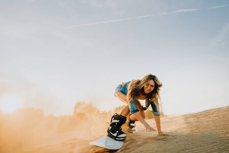 Tourist Sandboarding sexy girl In the Desert Man jumps in and does the trick