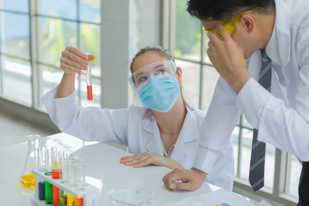 Scientists holding test tube of glass for examine the chemical results in chemical manufacturingの写真素材