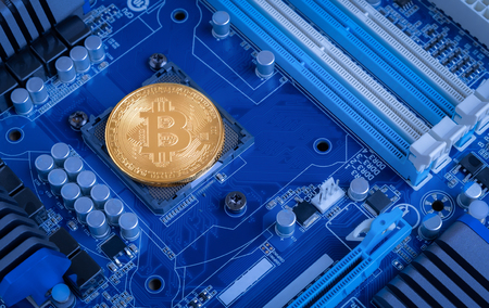 Gold bitcoin power drive on motherboardの写真素材